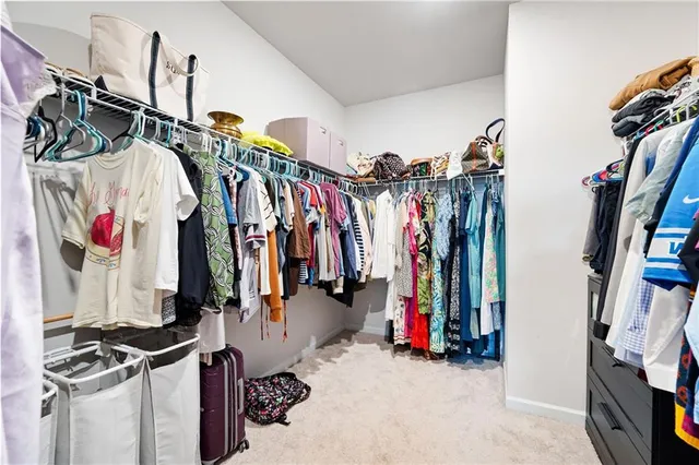 a view of walk in closet with clothes