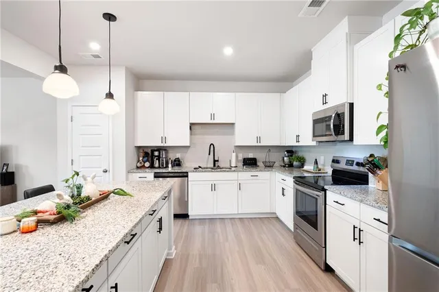a kitchen with stainless steel appliances granite countertop sink stove top oven and refrigerator
