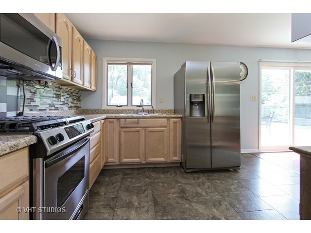 115 East Oltendorf Road Streamwood, IL 60107 - Photo 3 of 10 a kitchen with stainless steel appliances granite countertop a refrigerator a stove a sink and a microwave