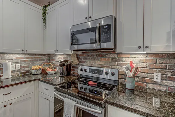 a kitchen with stainless steel appliances granite countertop a stove and a microwave