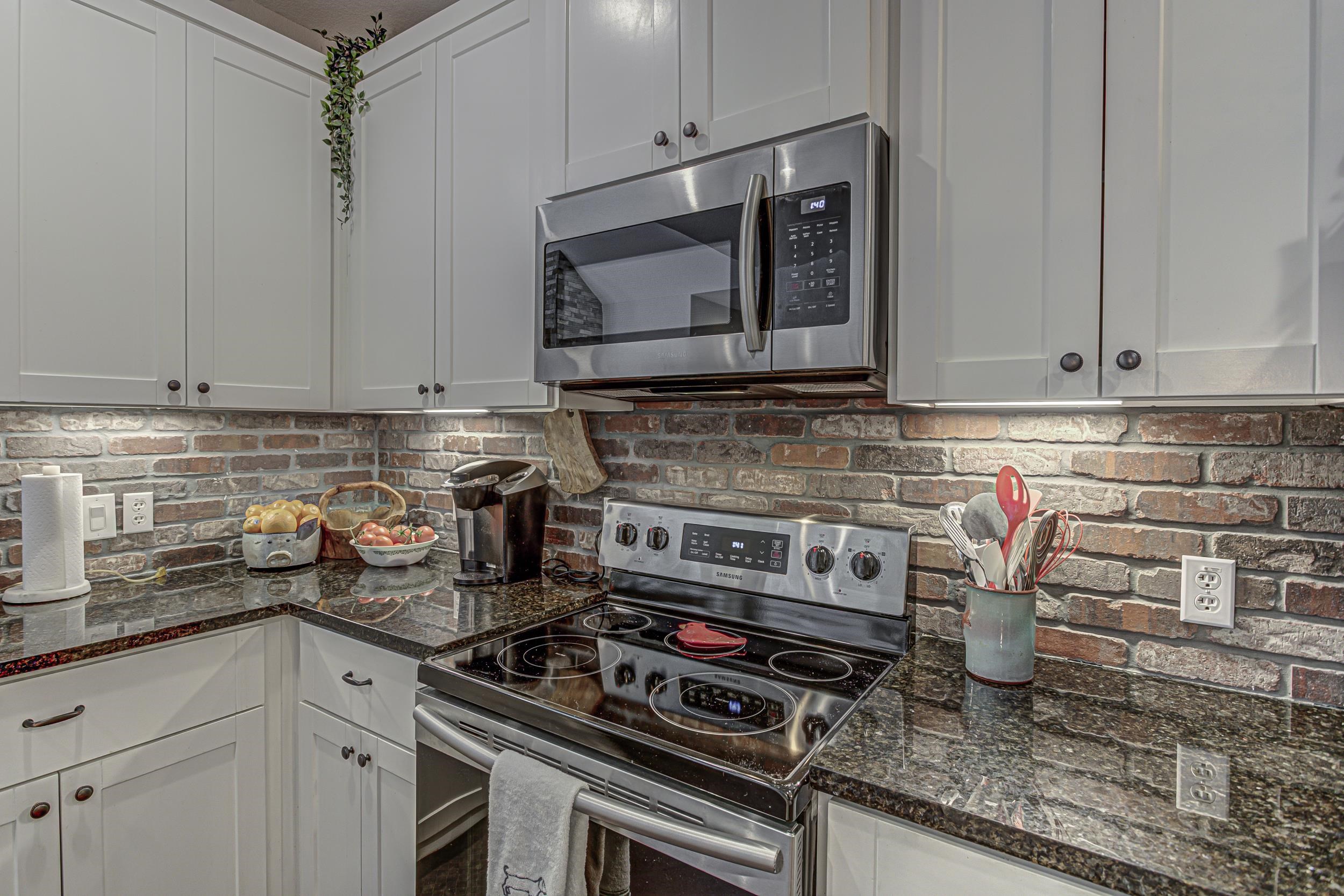 433 Dove Trail Bertram, TX 78605 - Photo 11 of 30 a kitchen with stainless steel appliances granite countertop a stove and a microwave