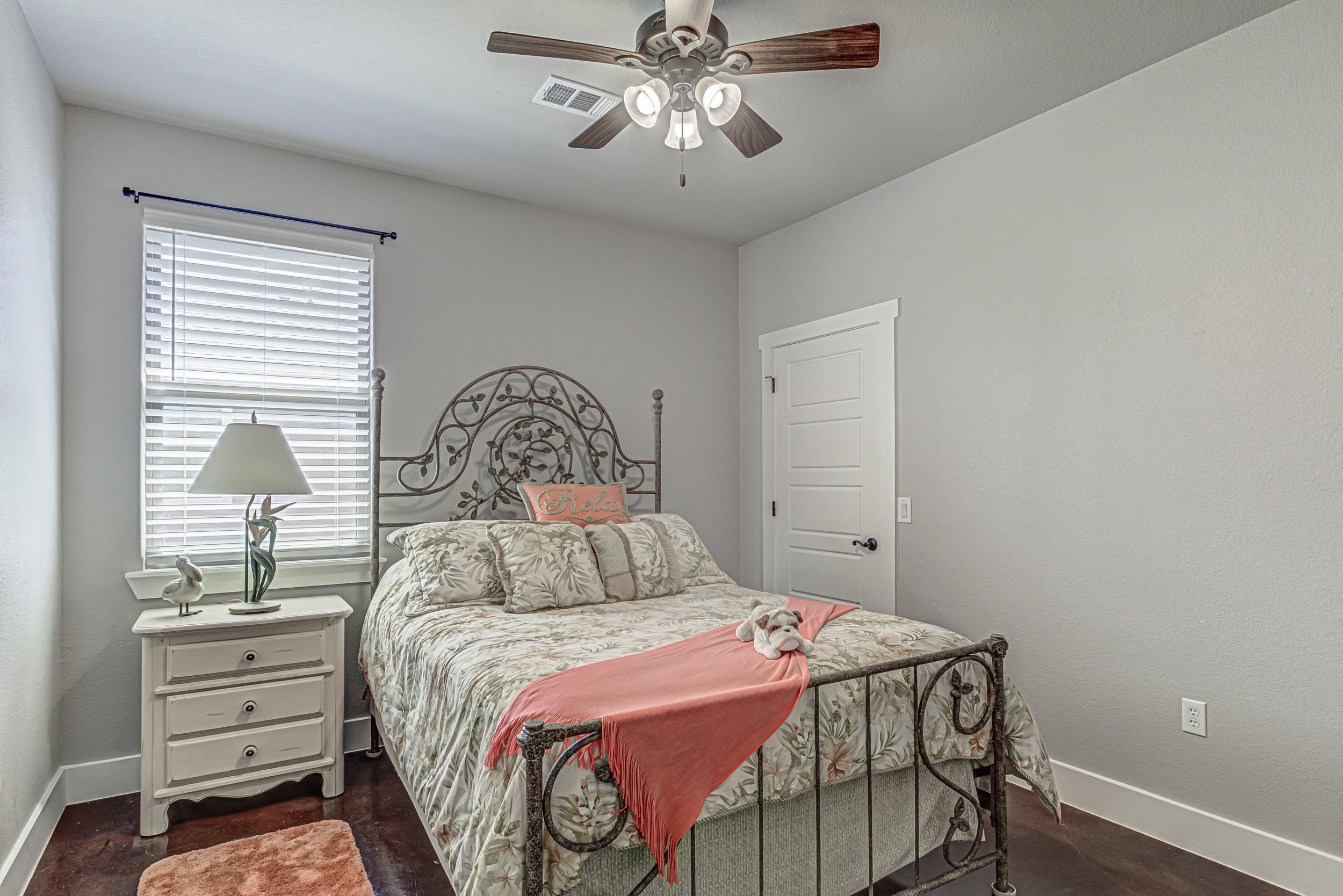 433 Dove Trail Bertram, TX 78605 - Photo 20 of 30 a bedroom with a bed and a chandelier