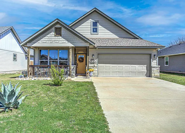 a front view of a house with a yard outdoor seating and garage