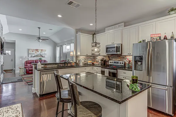 a kitchen with kitchen island a large counter appliances and cabinets