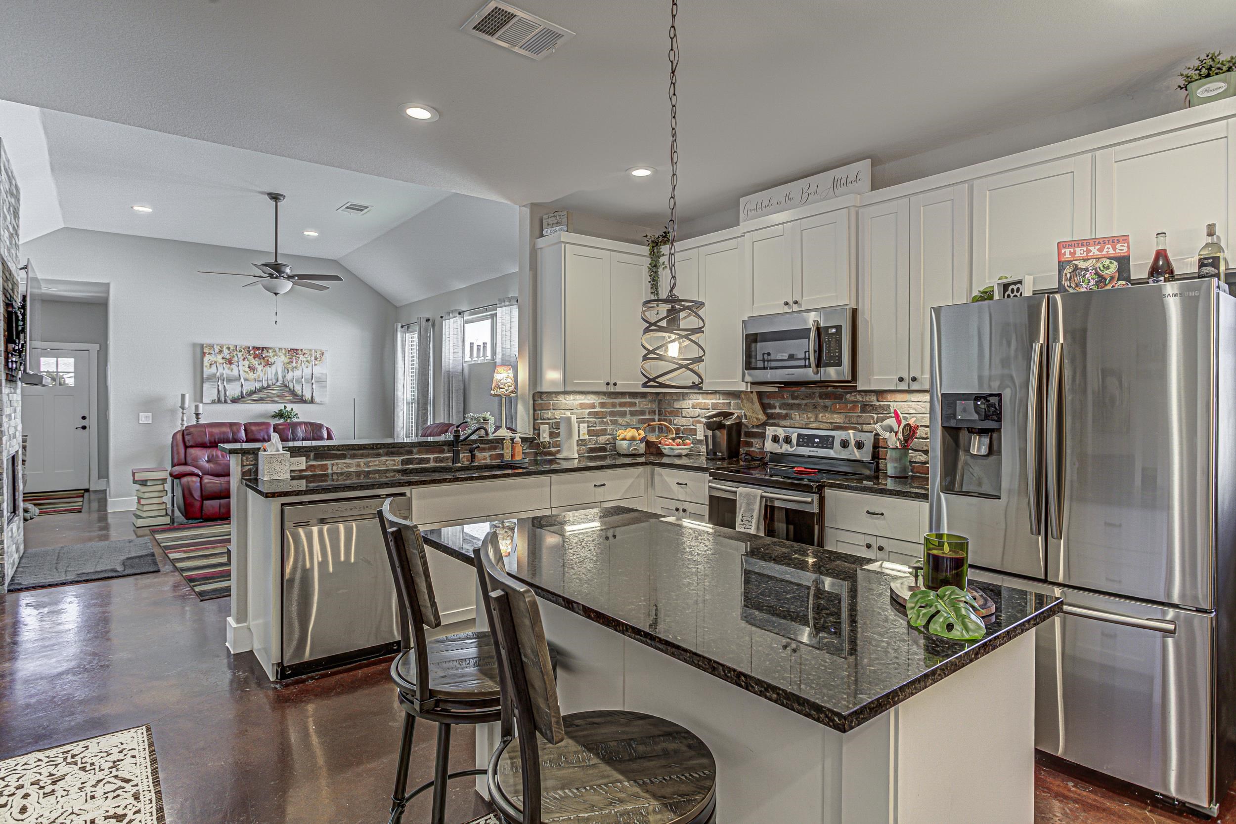 433 Dove Trail Bertram, TX 78605 - Photo 8 of 30 a kitchen with kitchen island a large counter appliances and cabinets