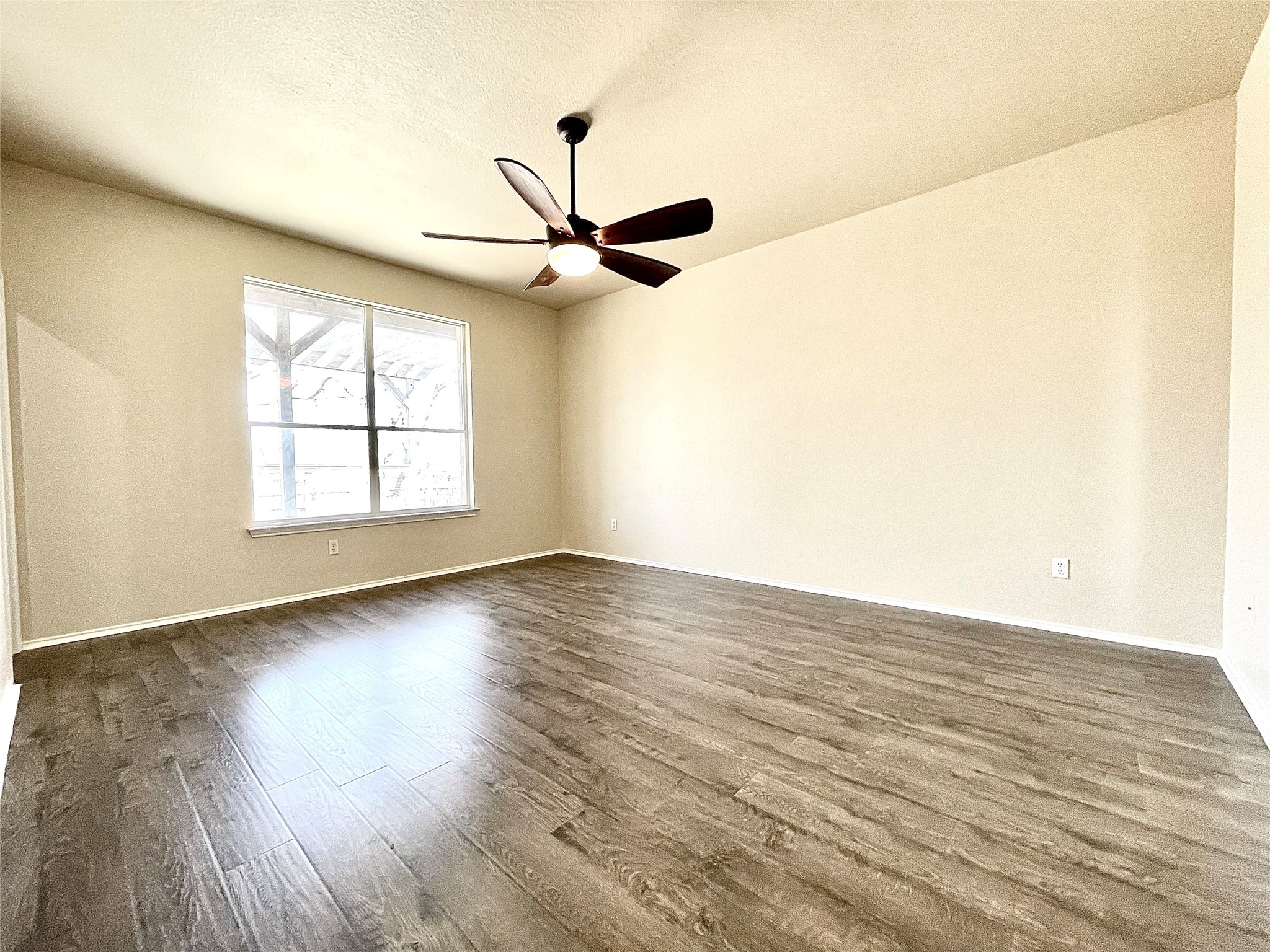 508 Emma Rose Trail Leander, TX 78641 - Photo 34 of 40 A spacious room features a wide window, offering natural light and a contemporary ceiling fan for comfort.