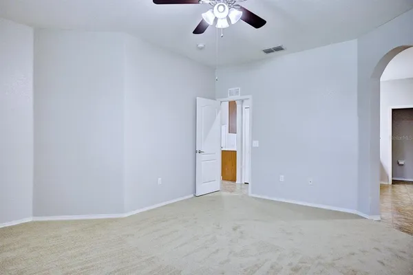 an empty room with a empty space and chandelier fan