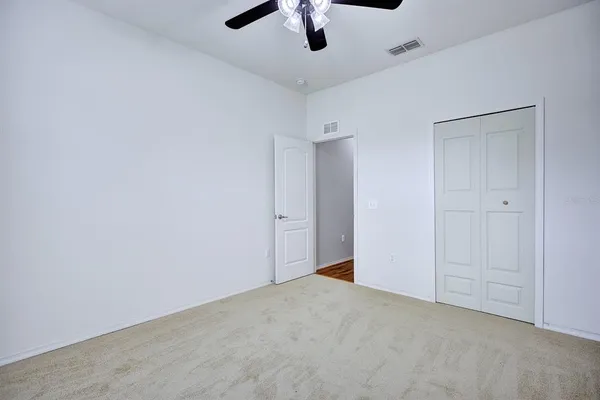 an empty room with a ceiling fan and a window