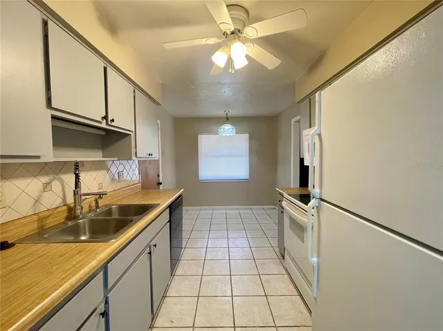 a kitchen with a sink a refrigerator and cabinets