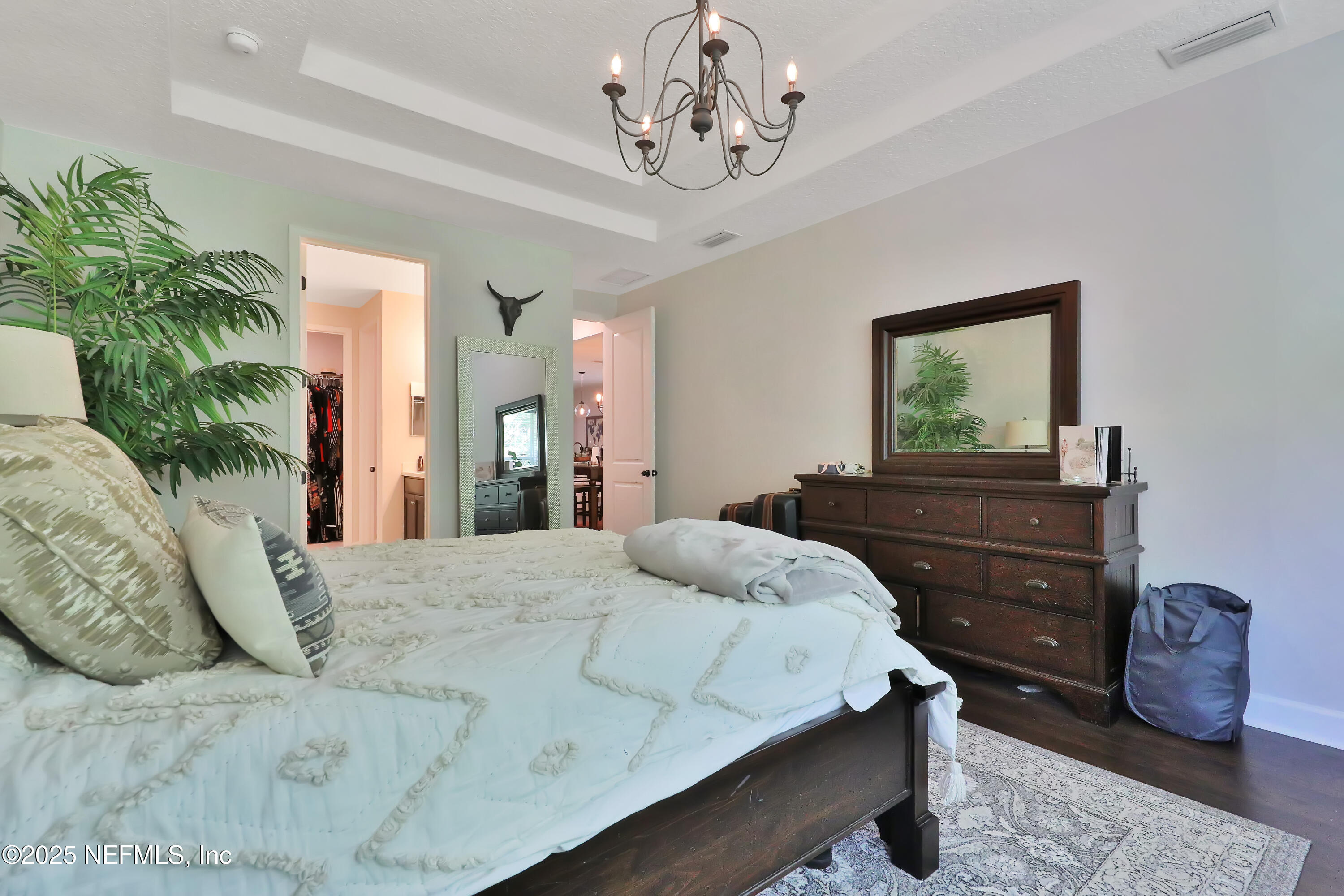 123 Bison Trail Ponte Vedra, FL 32081 - Photo 16 of 23 a bedroom with a bed and a chandelier