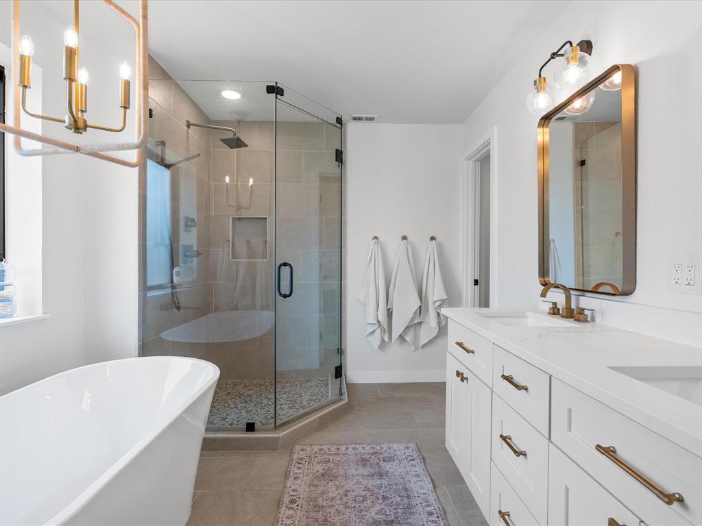 946 Burke Road Gunter, TX 75058 - Photo 15 of 38 a spacious bathroom with a double vanity sink toilet mirror and bathtub
