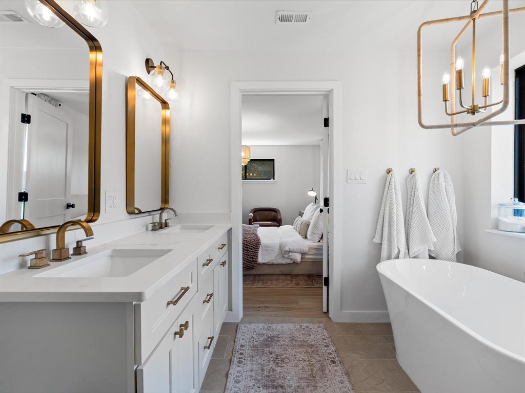 946 Burke Road Gunter, TX 75058 - Photo 16 of 38 a bathroom with a double vanity sink a mirror and a bathtub