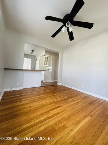 a view of a room and kitchen with wooden floor