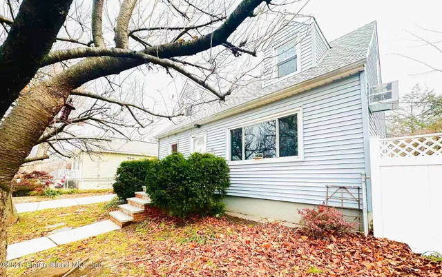 a view of a backyard with plants and a bench