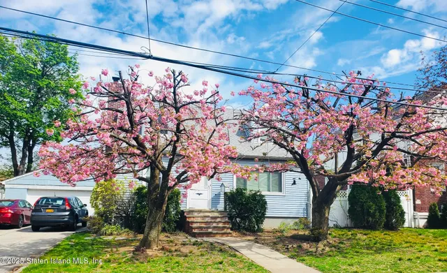 a backyard of a house with table and chairs under an umbrella