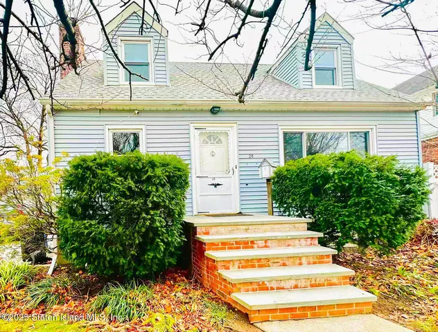 a view of a house with a large windows and flower plants