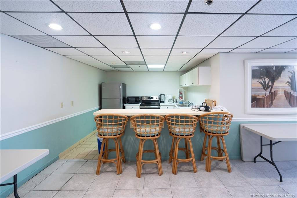 221 Northeast Plantation Road, Unit 407 Stuart, FL 34996 - Photo 16 of 42 a dining room with furniture and a chandelier
