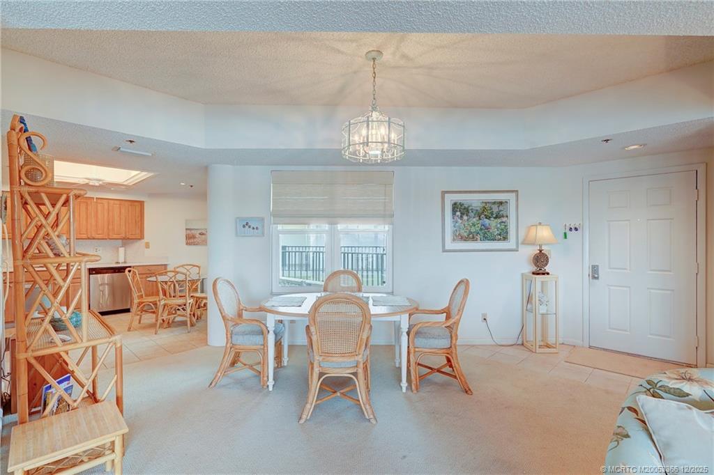 221 Northeast Plantation Road, Unit 407 Stuart, FL 34996 - Photo 21 of 42 a view of a dining room with furniture and chandelier