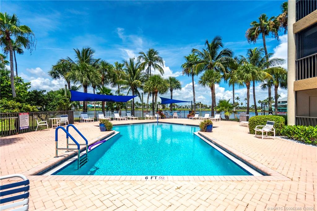 221 Northeast Plantation Road, Unit 407 Stuart, FL 34996 - Photo 41 of 42 a swimming pool with outdoor seating and yard