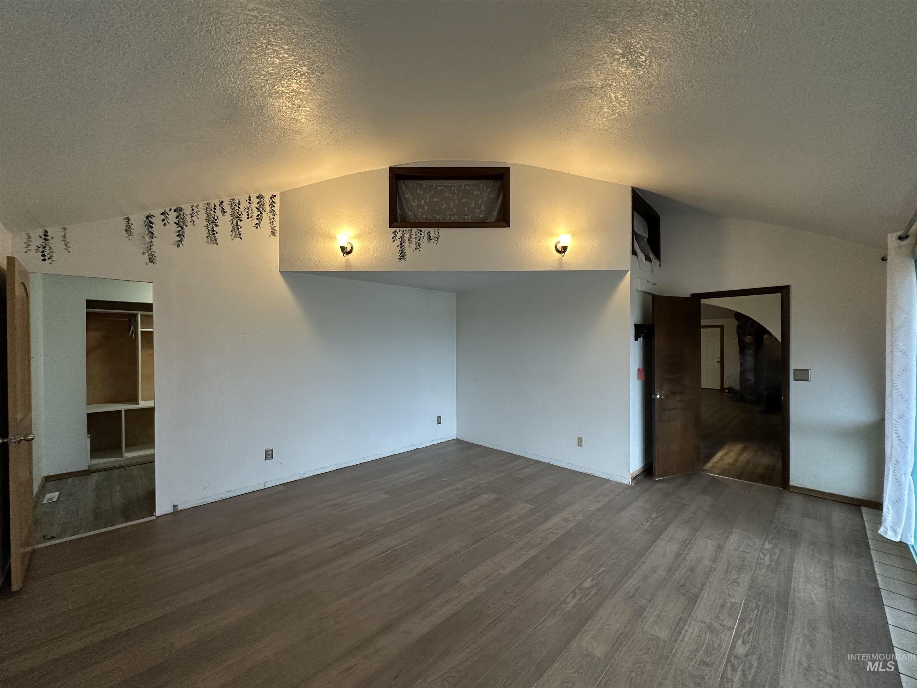 5860 Akron Road New Plymouth, ID 83655 - Photo 13 of 33 Unfurnished living room with a textured ceiling, wood finished floors, and lofted ceiling
