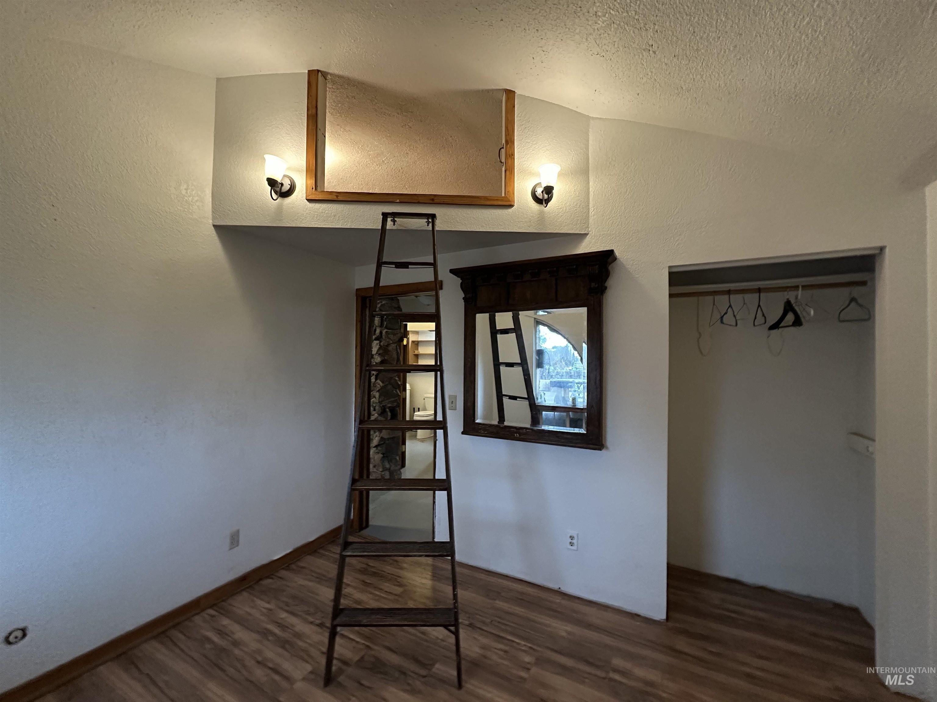 5860 Akron Road New Plymouth, ID 83655 - Photo 15 of 33 Unfurnished bedroom featuring a textured wall, dark wood-style flooring, and a closet