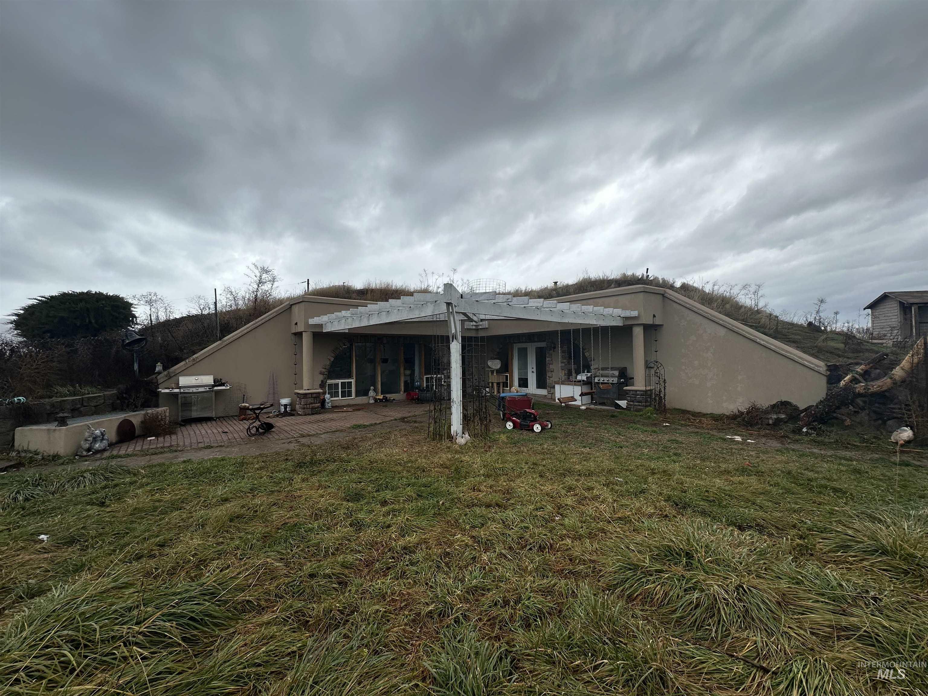 5860 Akron Road New Plymouth, ID 83655 - Photo 31 of 33 Back of property with a patio area, a lawn, stucco siding, and a pergola