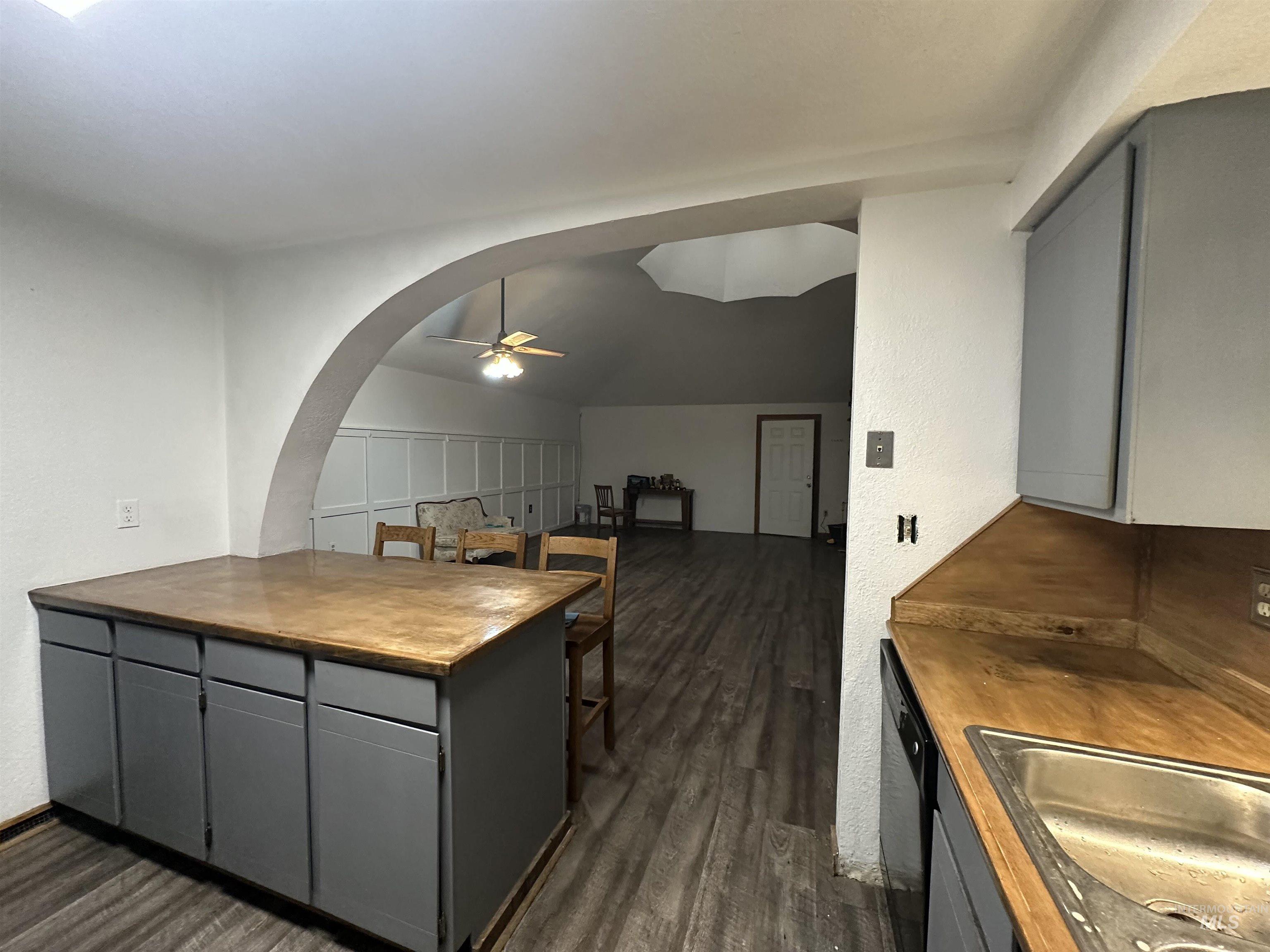 5860 Akron Road New Plymouth, ID 83655 - Photo 8 of 33 Kitchen featuring gray cabinetry, vaulted ceiling, a peninsula, ceiling fan, and dark wood-style floors