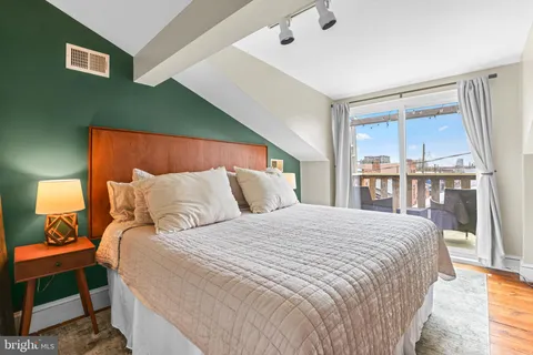 a large bed sitting in a bedroom next to a window