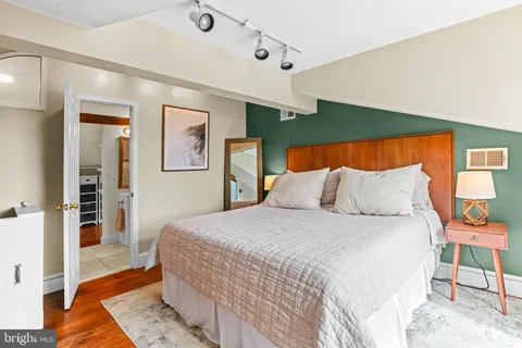 a bedroom with a large bed and a chandelier