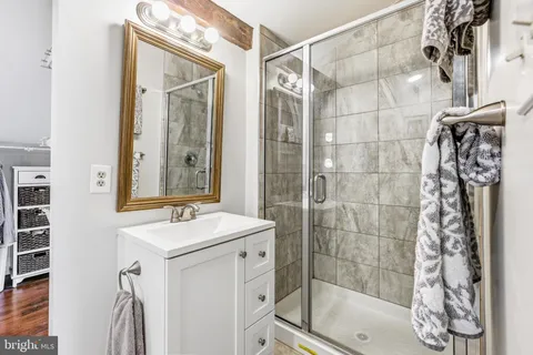 a bathroom with a shower a mirror and a sink