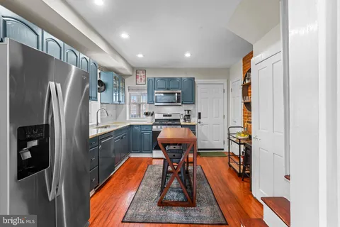 a kitchen with stainless steel appliances granite countertop a refrigerator and a stove top oven