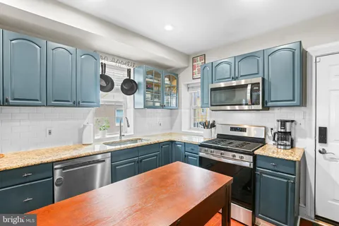 a kitchen with stainless steel appliances a sink cabinets and a stove top oven