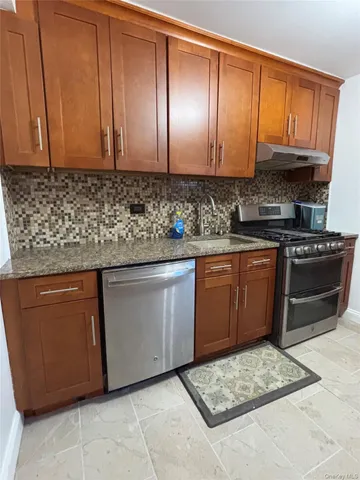 a kitchen with stainless steel appliances granite countertop a stove a sink dishwasher and a microwave