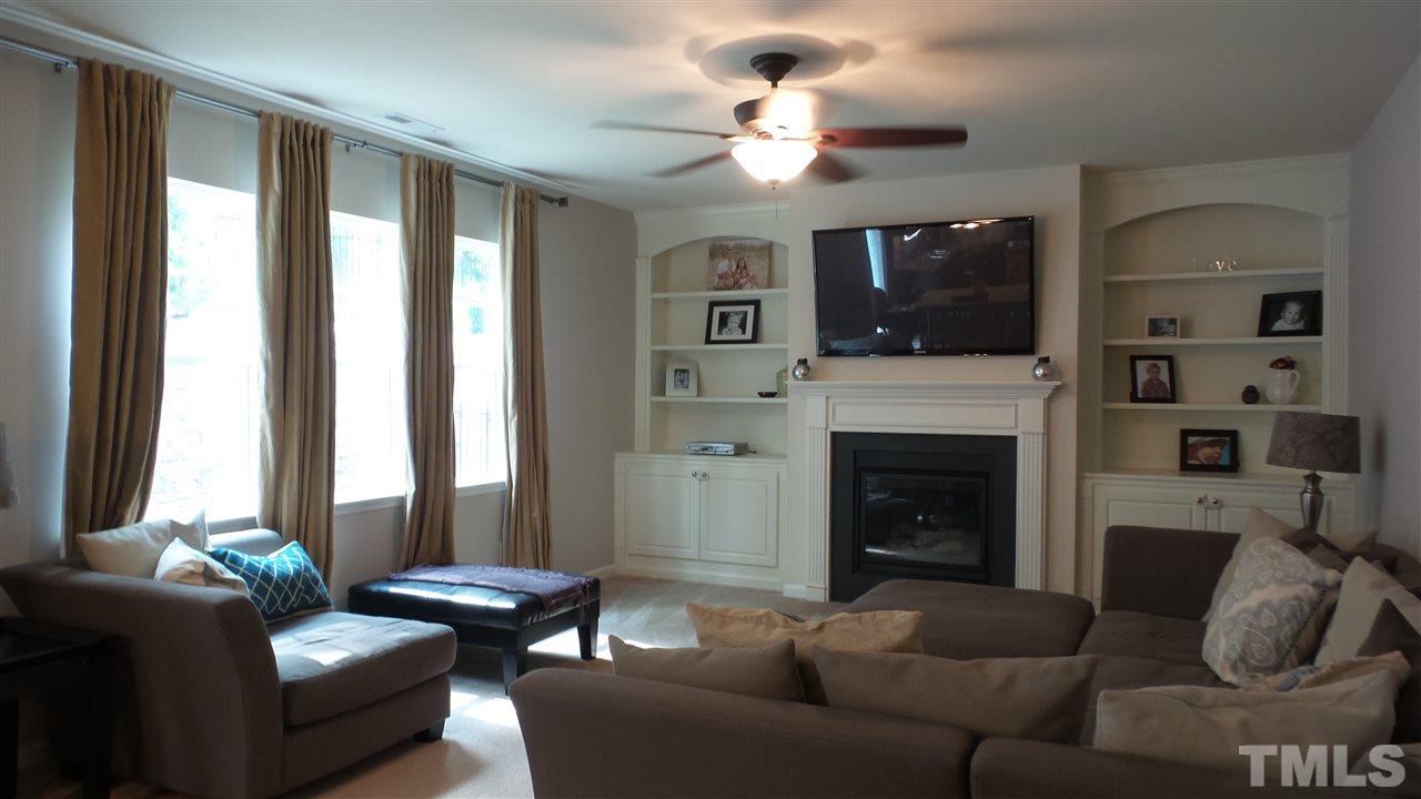 1151 Alsace Drive Apex, NC 27502 - Photo 8 of 25 Large Family Room features a 'wall of windows", fireplace, ceiling fan and beautiful Built In Cabinets!