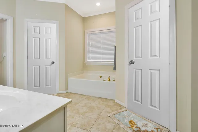 a bathroom with a tub shower and a sink