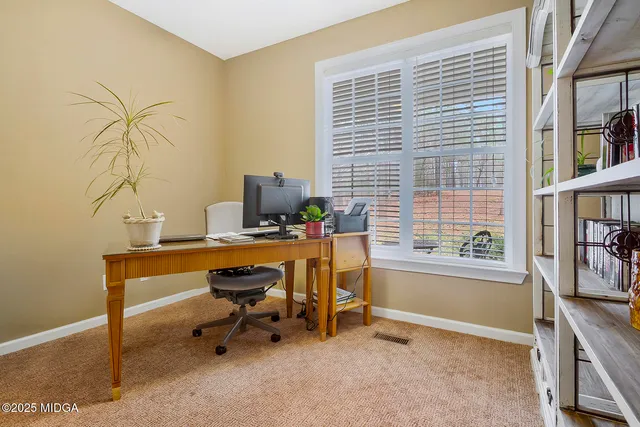 a view of a workspace with furniture and a window