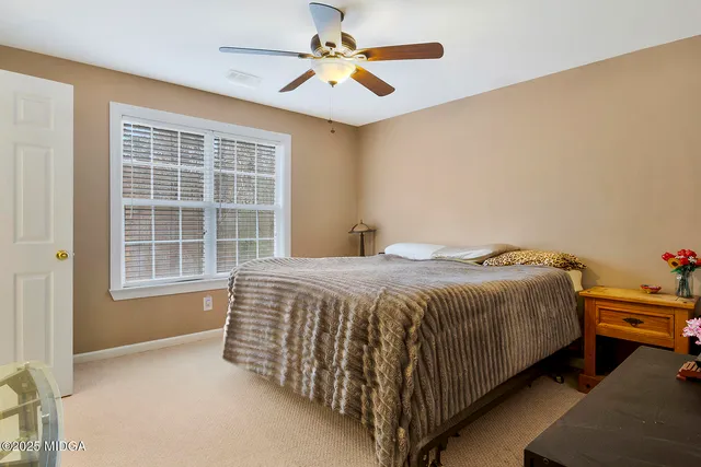 a spacious bedroom with a bed and a chandelier