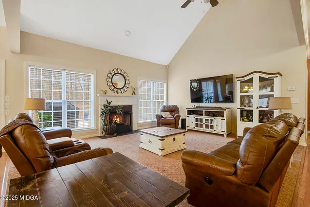 a living room with furniture a fireplace and a flat screen tv