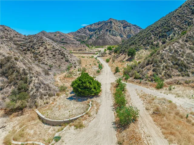 a view of a dry field with mountains in the background