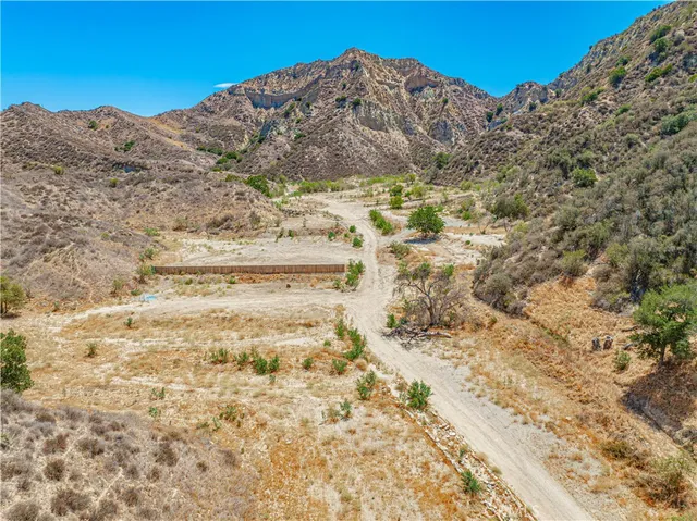 a view of a dry field with mountains in the background