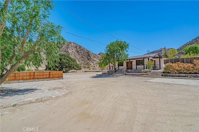 a view of a house with a yard and potted plants