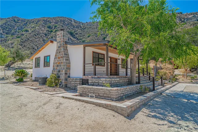 a backyard of a house with large trees and covered with wooden fence