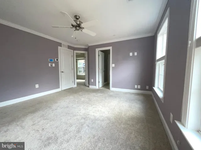 a view of a livingroom with a ceiling fan and window