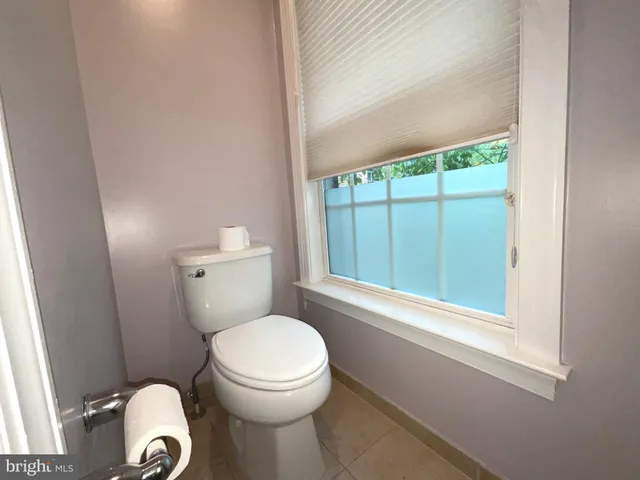 a white toilet sitting next to a window