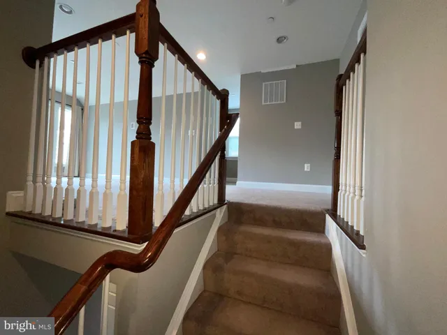 a view of staircase with lots of frames on wall and a window