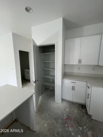 a kitchen with white cabinets and sink