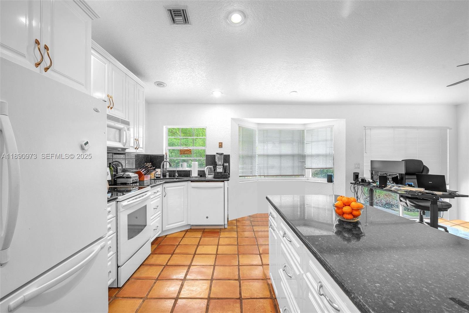 9690 Northwest 39th Street Cooper City, FL 33024 - Photo 11 of 30 a kitchen with stainless steel appliances granite countertop a sink stove and cabinets