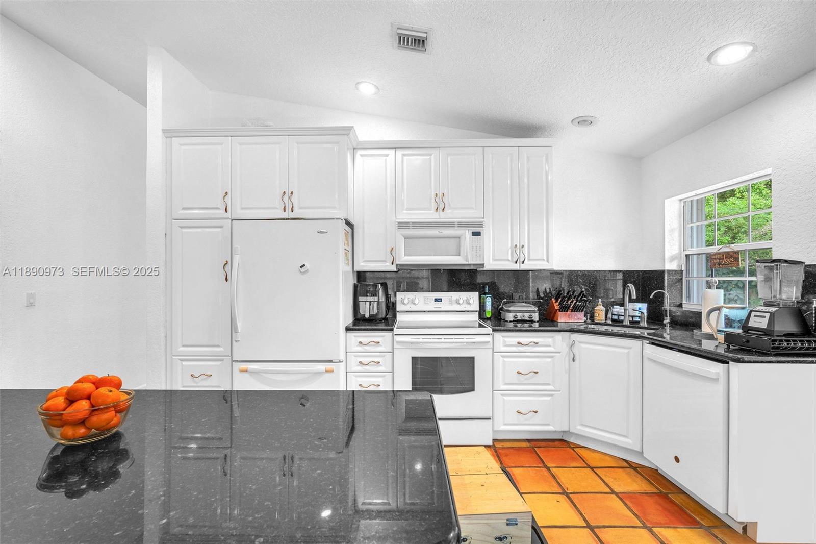 9690 Northwest 39th Street Cooper City, FL 33024 - Photo 9 of 30 a kitchen with stainless steel appliances granite countertop a stove a sink and white cabinets