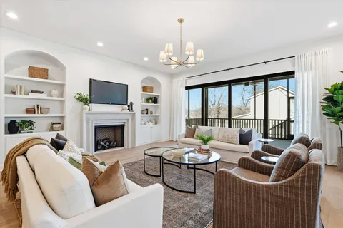 a living room with furniture a fireplace and a chandelier