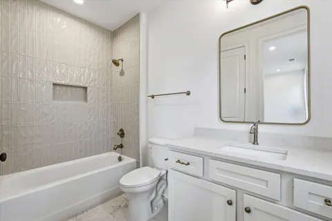 a bathroom with a granite countertop toilet a sink and bathtub